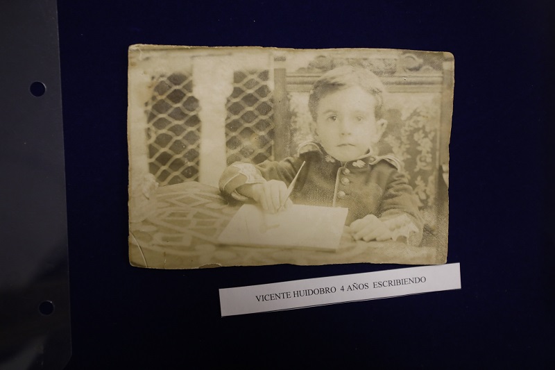 Fotografía de una foto del archivo donde aparece Vicente Huidobro a sus 4 años, escribiendo.