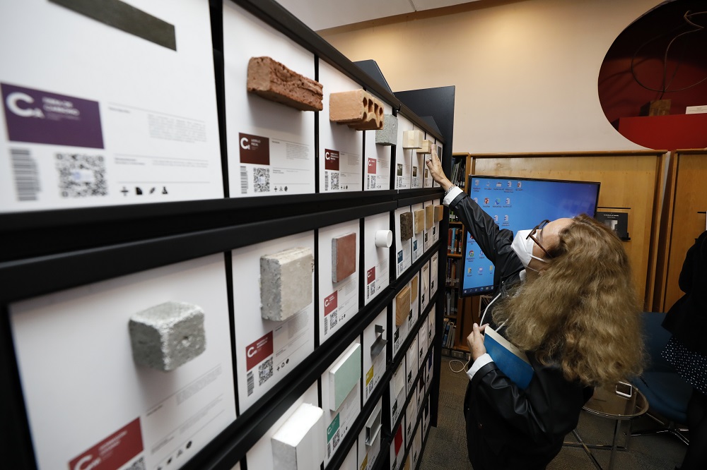 Foto. Una mujer escanea con su teléfono un material exhibido en la Materioteca de Biblioteca Lo Contador. 