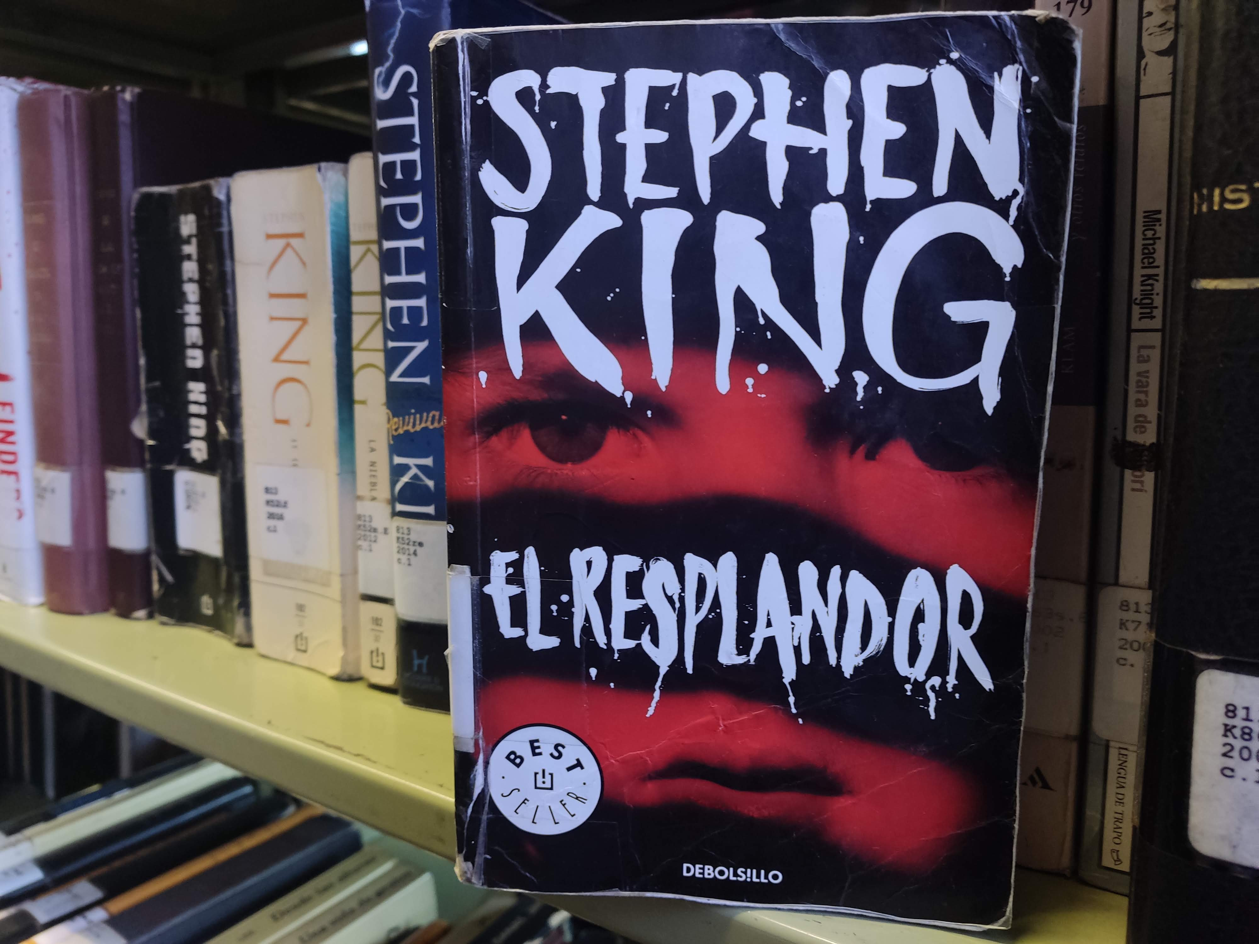 Libro "el respplandor" sobre una estantería de libros.
