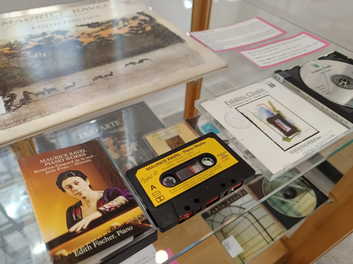 Fotografía de vitrina con material de la pianista Edith Fisher: casete, CD y vinilo.