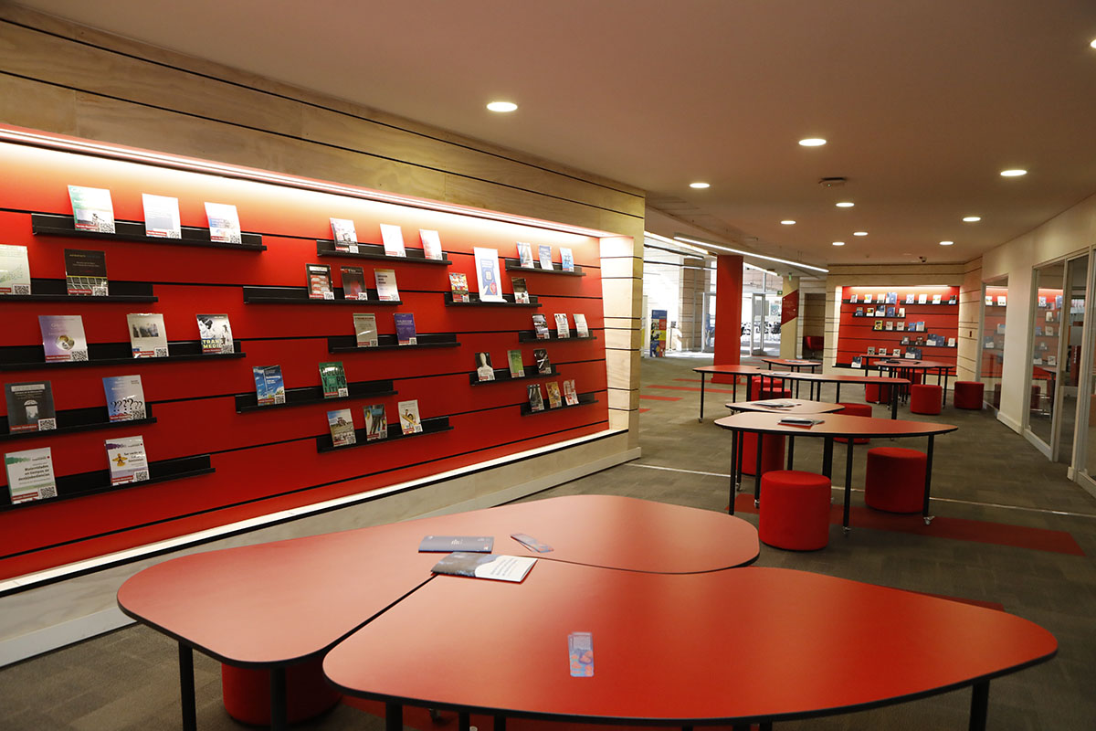 Fotografía del espacio dedicado a la colección de género en biblioteca san joaquín. Aparecen las estanterías con libros, las mesas y sillones.